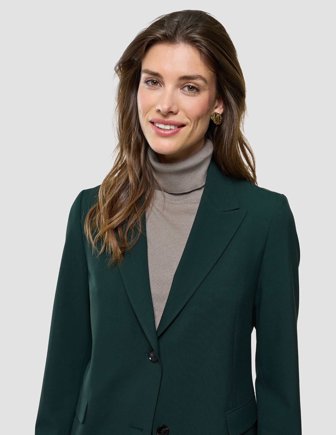 Ease Blazer Regular i Evergreen, halvfigur af kvinde iført mørkegrøn blazer og grå rullekrave.